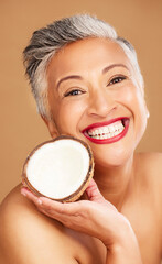 Obraz na płótnie Canvas Senior woman, skincare and coconut in studio for beauty, health and wellness in happy cosmetic portrait. Healthy, elderly black woman and fruit by face for cosmetics, skin and happiness by background