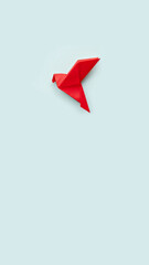 one red paper origami pigeon on pastel blue background, vertical, 16:9