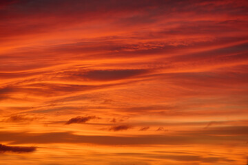 Sunset with sun and clouds on blue and orange dramatic sky.