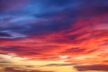Naklejka na ściany i meble Sunset with sun and clouds on blue and orange dramatic sky.