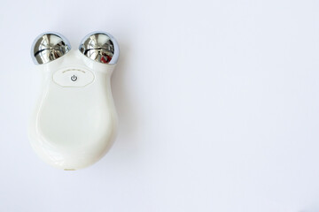 Microcurrent Facial Massager. Device for home use to fight aging and tighten the face on a pink...