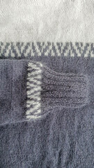 Handmade sweater. Knitted fabric from mink thread. White and gray color pattern.