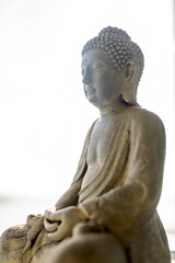 Close-up of buddha sculpture against sky