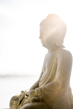 Close-up of buddha sculpture against sky