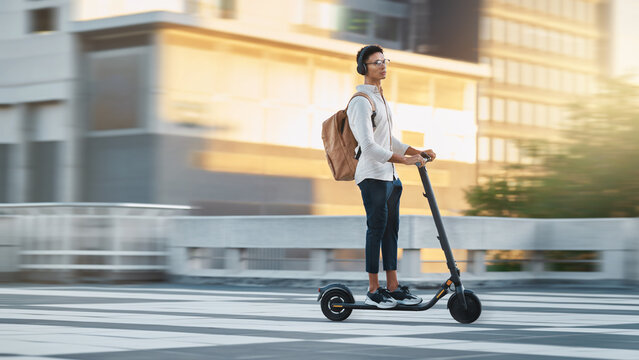 Electric scooter, travel fast or businessman with transport in city, street or road in London. Employee, worker or designer black man with bike commute to work, office or university in the morning