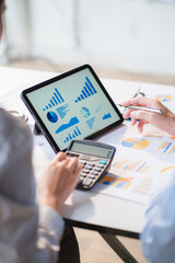 Group of business people meeting together Pointing to the graph assess business profits.