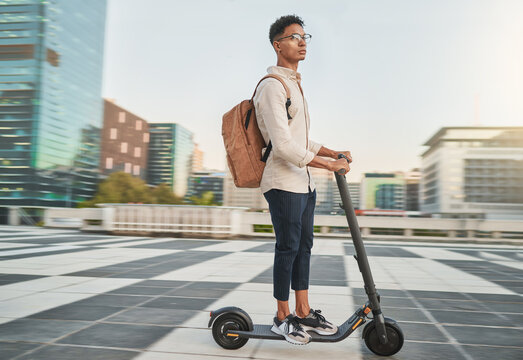 Travel, scooter and student in city, street or outdoors on road on eco  friendly transportation. Technology, sustainability and male from India on  electric moped commuting to college or university. Stock Photo