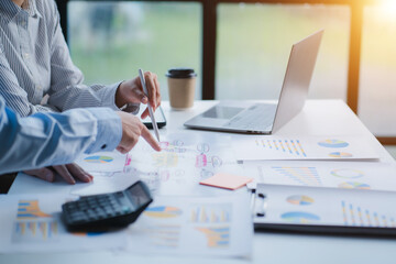 Group of business people meeting together Pointing to the graph assess business profits.