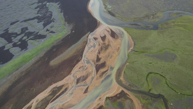 Aerial view of water formation along the coastline at river estuary in Iceland.