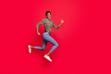 Fototapeta na wymiar Full length body size view of attractive trendy girl jumping running having fun isolated over vivid red color background