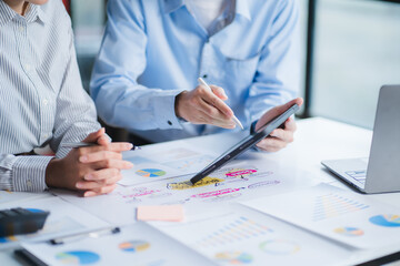 Group of business people meeting together Pointing to the graph assess business profits.