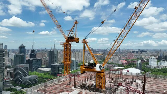 Cranes and construction site in the city. Drone aerial view. House development project and building in construction in Shanghai China.  Industry, business, house development concept b-roll footage.
