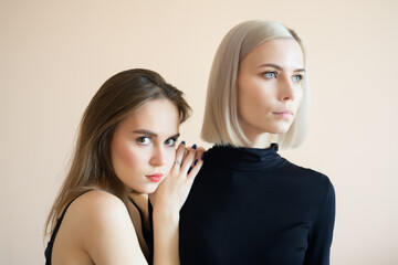 Two young women on a light background.