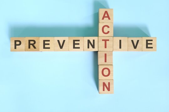 Preventive action business concept.  Wooden blocks crossword puzzle flat lay.