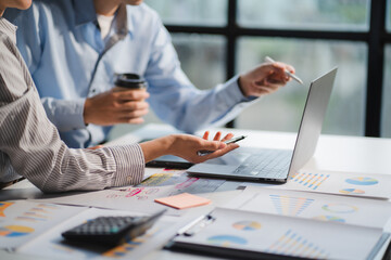 Group of business people meeting together Pointing to the graph assess business profits.