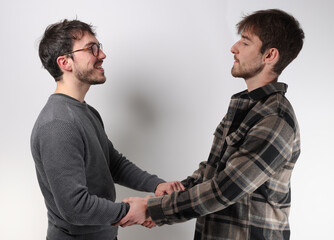 deux jeunes hommes se serrent la main pour se dire bonjour ou pour conclure un accord © Tof - Photographie