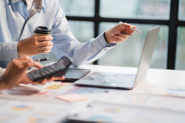Group of business people meeting together Pointing to the graph assess business profits.