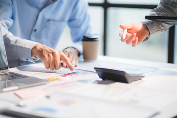 Group of business people meeting together Pointing to the graph assess business profits.