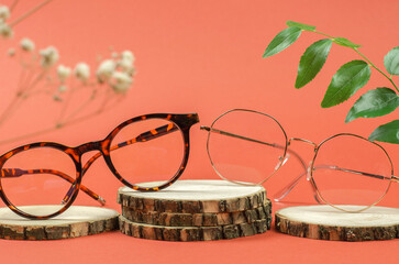Two stylish glasses on a wooden podium. Sale of eyeglasses.