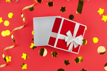Open gift box on a red festive background, close-up. open small gift box