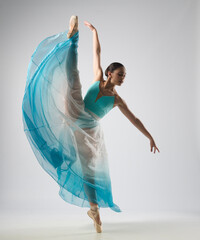 Beautiful ballerina dancing with blue and white clothes. She danced on ballet pointe shoes. 