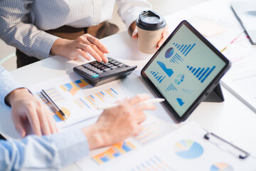 Group of business people meeting together Pointing to the graph assess business profits.