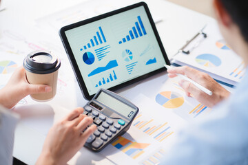 Group of business people meeting together Pointing to the graph assess business profits.