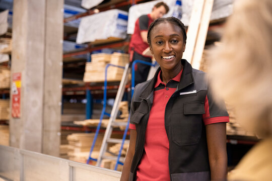 Smiling saleswoman talking to female customer at hardware store