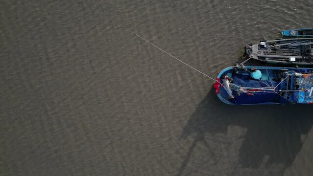 Aerial drone footage above fishermen boats in the sea, Rach Gia, Kien Giang province, south vietnam. Camera looks down and move slowly from left to right.