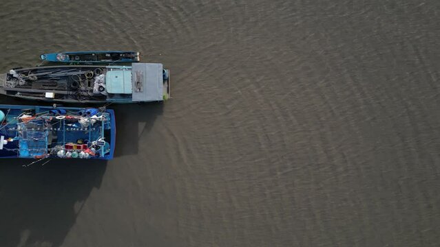 Drone footage above fishermen boat on the sea near Rach Gia city, Kien Giang province. Camera is moving from right to left above the boats.