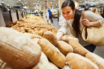 Kundin mit Einkaufstasche vor dem Brot Sortiment