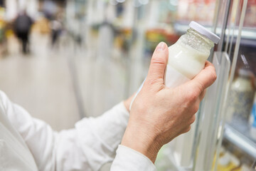 Hand eines Kunden beim Einkaufen von Mandelmilch