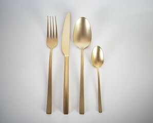 Gold cutlery on white background 