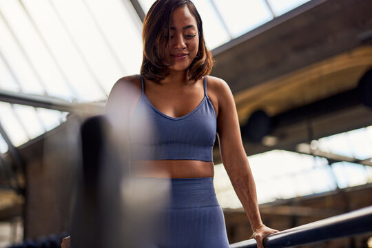 Smiling woman exercising on parallel bars in a gym