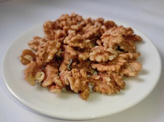 Walnuts on a white plate on a white background
