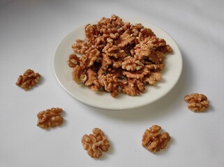 Walnuts on a white plate on a white background