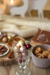 Cup of tea or coffee, various sweets and spices, Christmas decorations, comfy blanket, books and glasses. Selective focus.