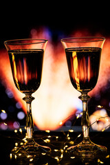 Christmas New Year background concept. Two glasses with champagne sparkling wine on a winter evening background. The atmosphere of celebration, magic and happiness.
