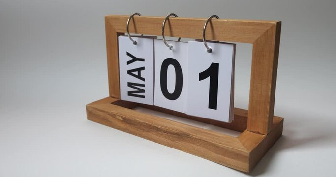 The May 1 in a desk perpetual calendar against a white wall background. International Workers Day. Spring holidays