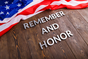 Fototapeta na wymiar Words Remember And Honor Laid With Silver Metal Letters On Wooden Background With Usa Flag Above