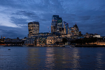 Fototapeta na wymiar View Of Illuminated Modern Financial District Skyscrapers From River Thames