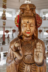 The Temple of Mercy (Guanyin) in Chiang Rai, Thailand sits on top of a mountain has a series of wooden female Buddha figures upstairs in the main temple building.