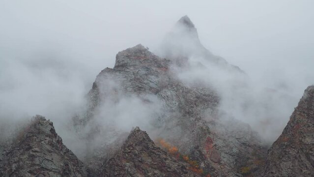Zoom in shot of clouds above the mountain peaks during the storm at Jispa in Lahaul Spiti district at Himachal Pradesh in India. Clouds covers the peaks of the mountains. Natural background. 