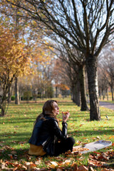 Obraz na płótnie Canvas Young girl eats pizza in the park enjoying autumn nature..