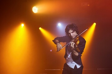 Violinist a player with a violin instrument in his hands. Artist of classical music or alternative music direction. Concept of stage art and performance. © Fotoproff