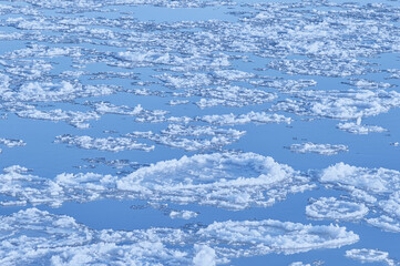 Fototapeta na wymiar Texture background of the surface of the river coastal ice close-up. No people. View from above. Copy space