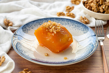 Turkish pumpkin dessert on wood floor. Traditional Turkish cuisine delicacies. Local name kabak tatlisi. close up