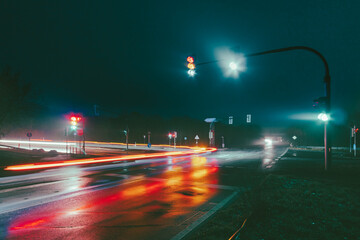 Traffic lights on a traffic junction in a rainy night