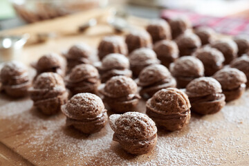 Homemade nut shaped Christmas cookies filled with chocolate cream on a table