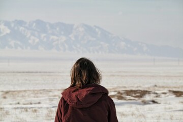 Back of a girl against the backdrop of snowy mountains. Almaty. Kazakhstan.